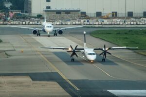 Two airplanes on a runway at an airport
